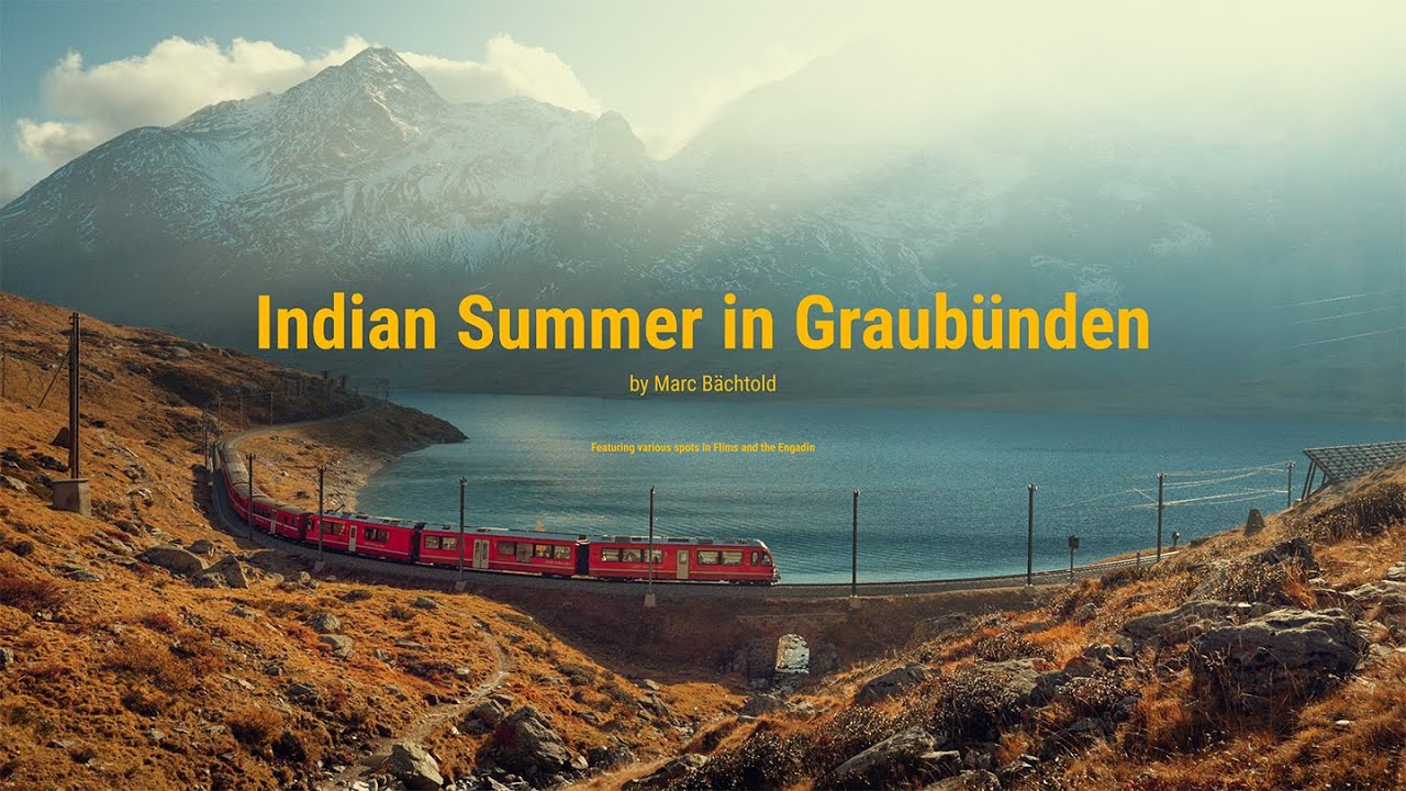 Red mountain train beside an alpine lake in autumn in Graubünden, Switzerland