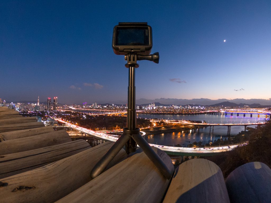 GoPro on a tripod overlooking a city at dusk
