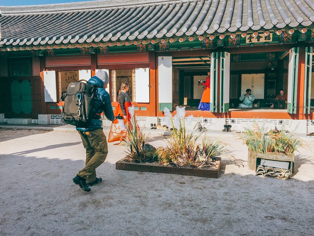 Camera operator filming a traveler at a Korean temple