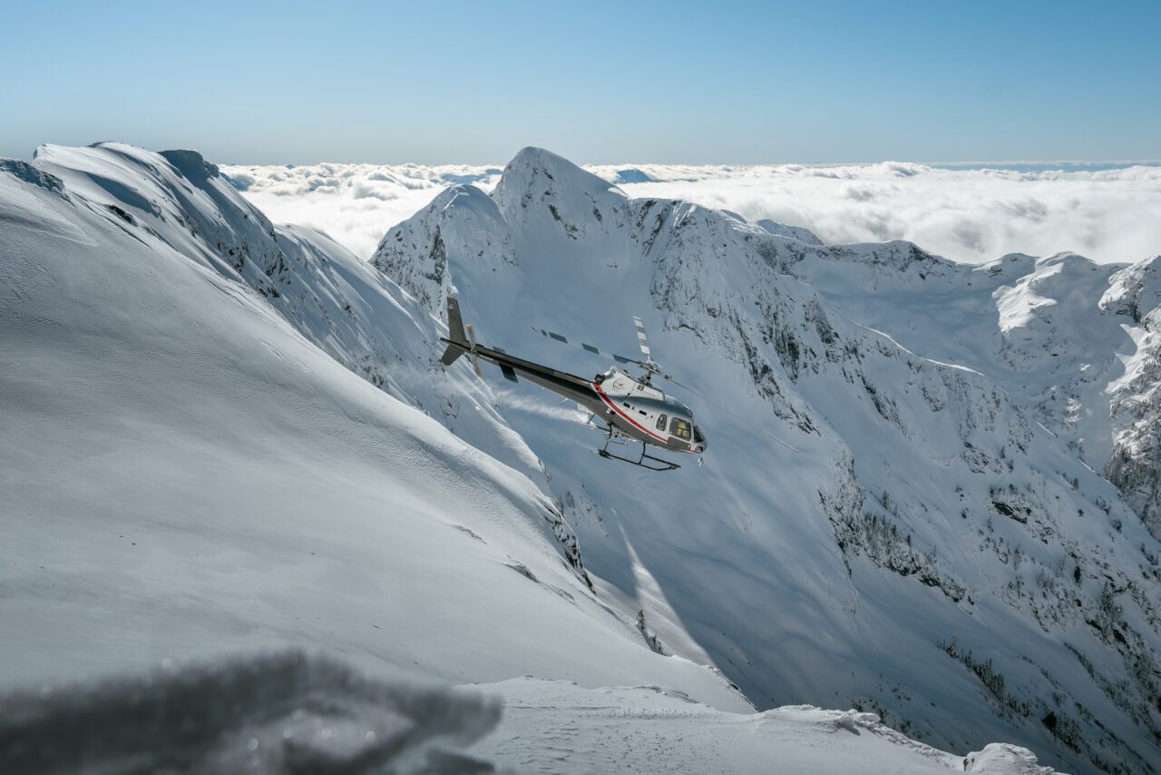 Helicopter crossing a steep alpine face during an outdoor flight