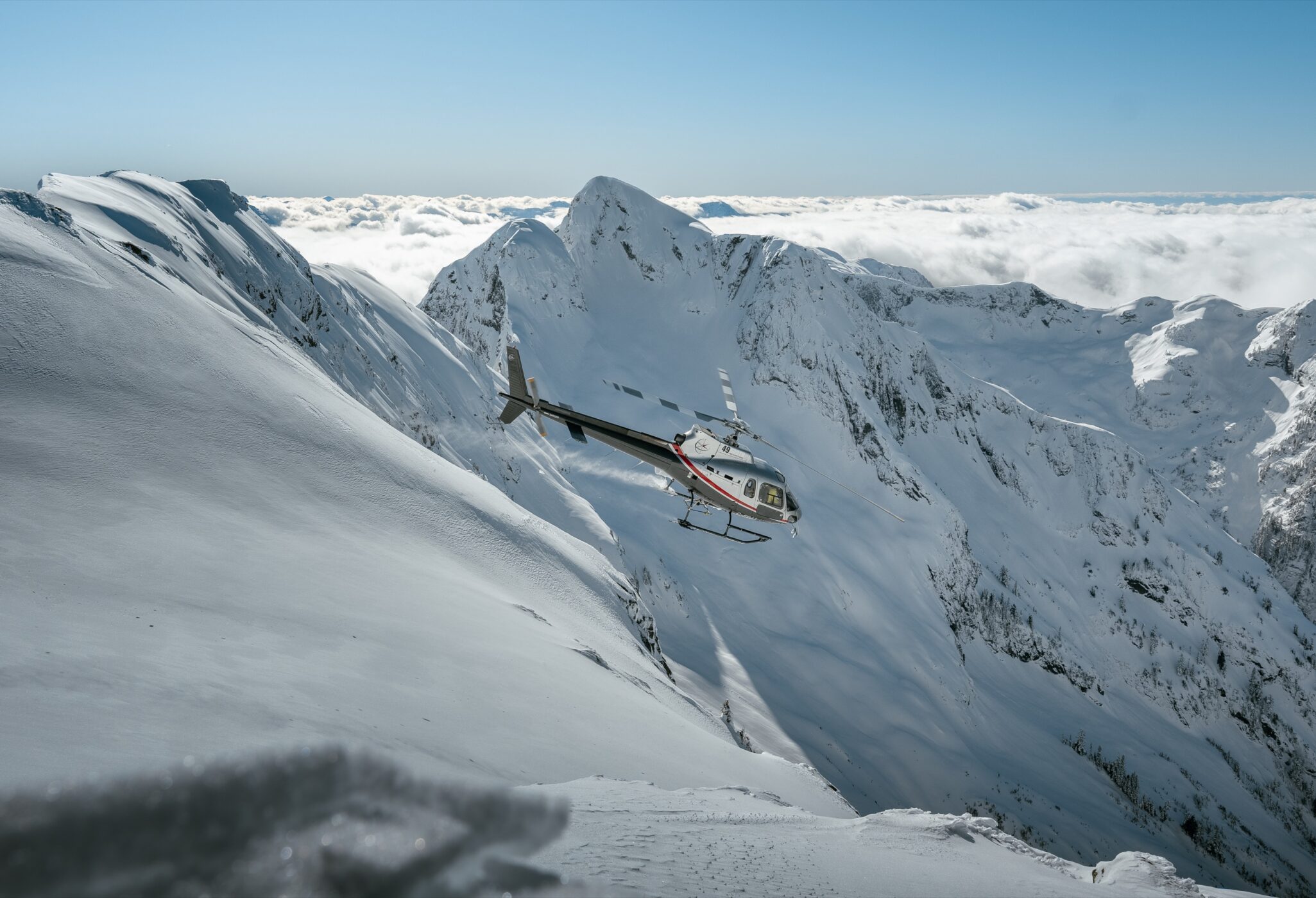 Helicopter crossing a steep alpine face during an outdoor flight