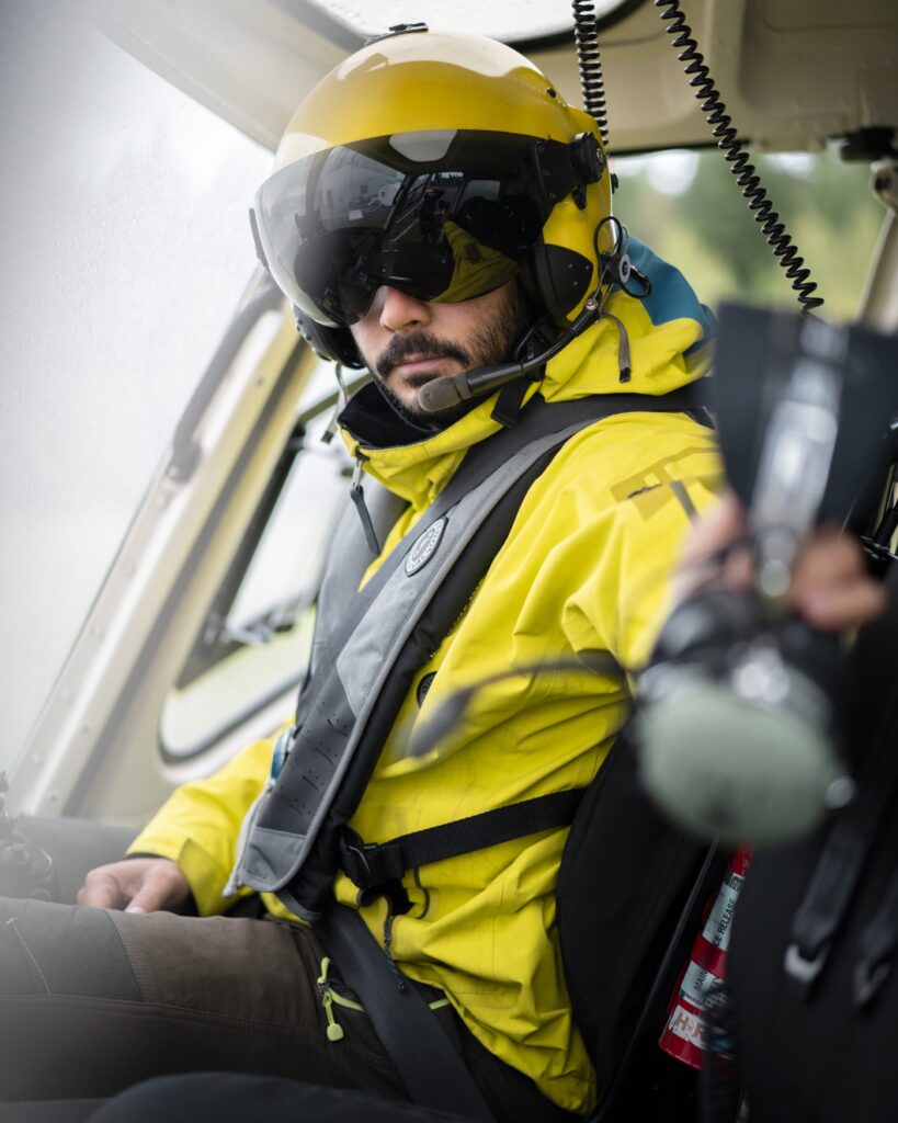 Helicopter crew member wearing flight gear inside the aircraft