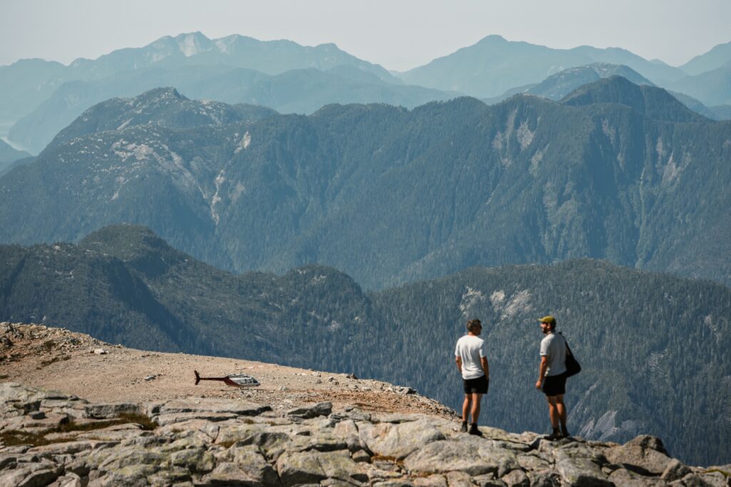 Two hikers looking across the mountains during a helicopter-accessed adventure
