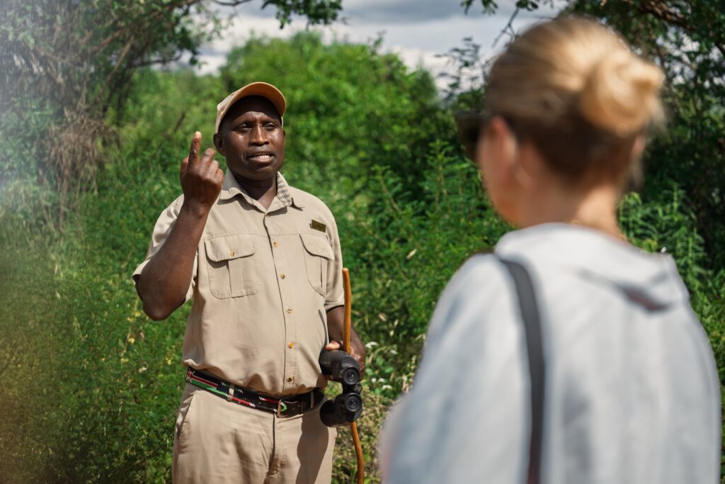 Kenyan safari guide explaining wildlife during a walking safari