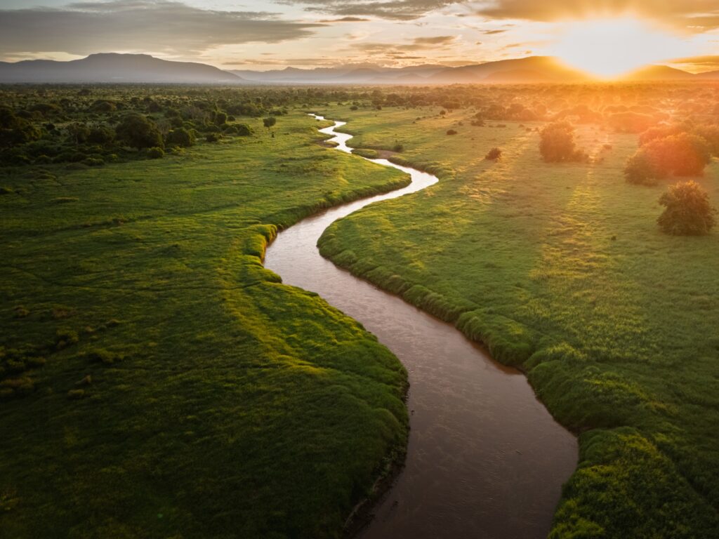River winding through green Kenyan grassland at sunset