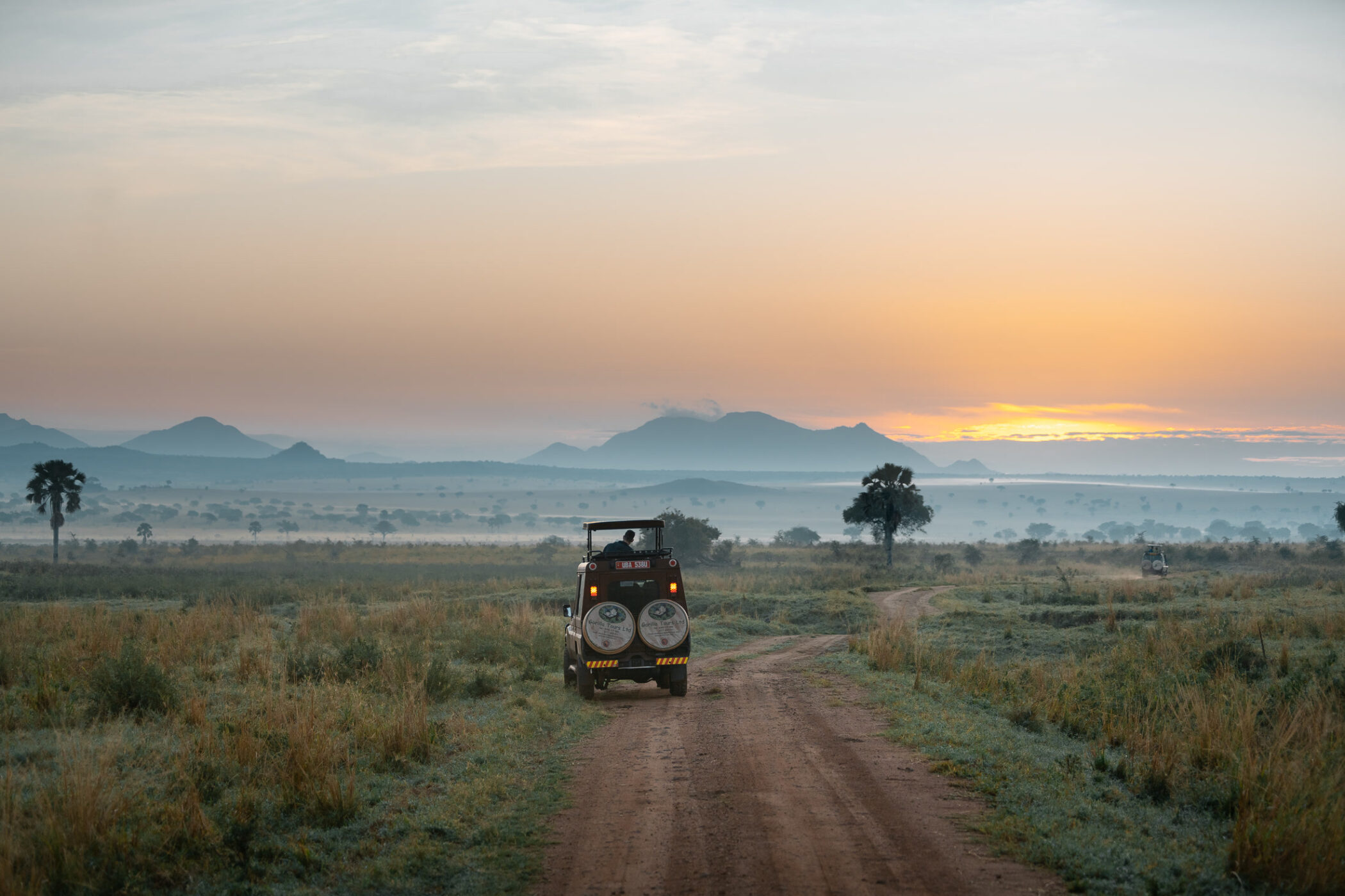 Safari vehicle travelling through Kidepo Valley at sunrise