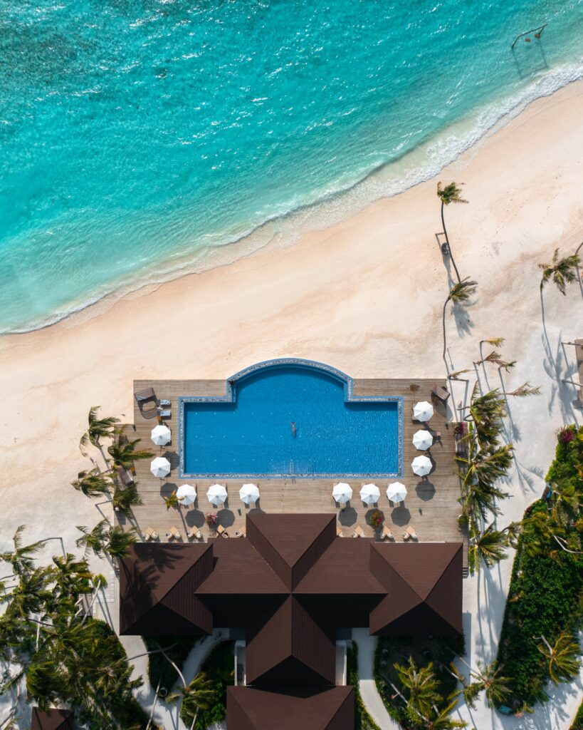 Resort pool and white-sand beach at Olhuveli from above
