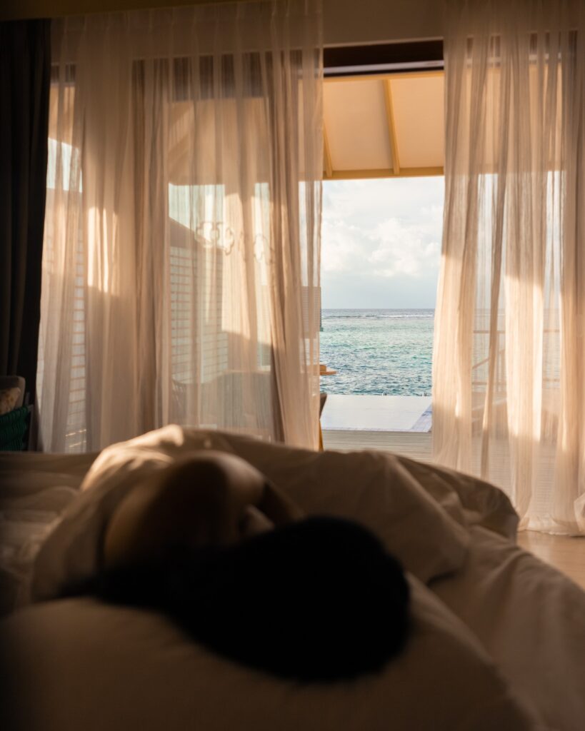 Water villa bedroom opening toward the ocean in the Maldives