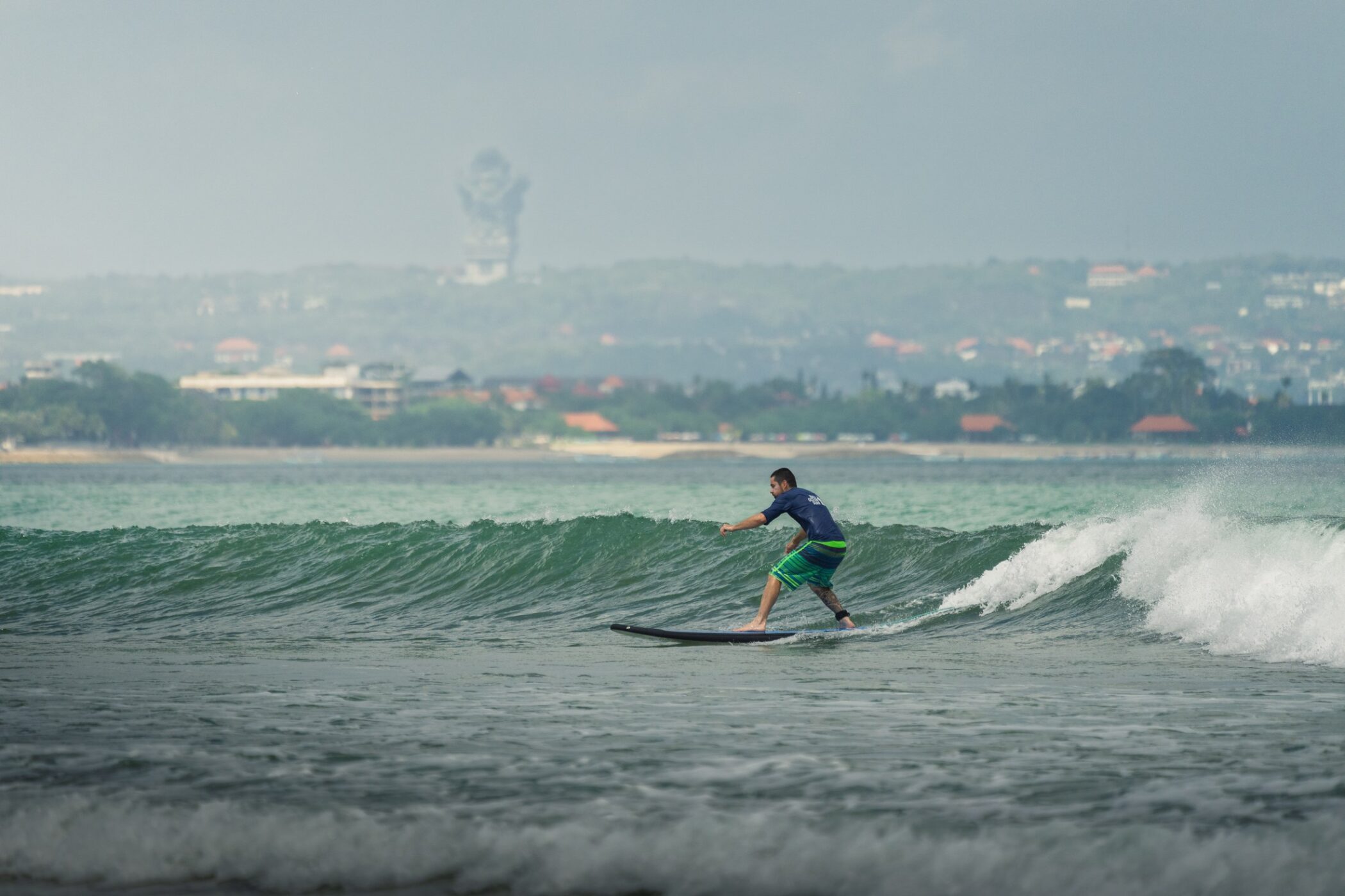 Surfer riding a wave off the coast of Bali