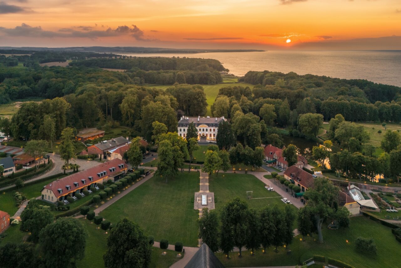 Aerial view of WEISSENHAUS resort and the Baltic Sea at sunset
