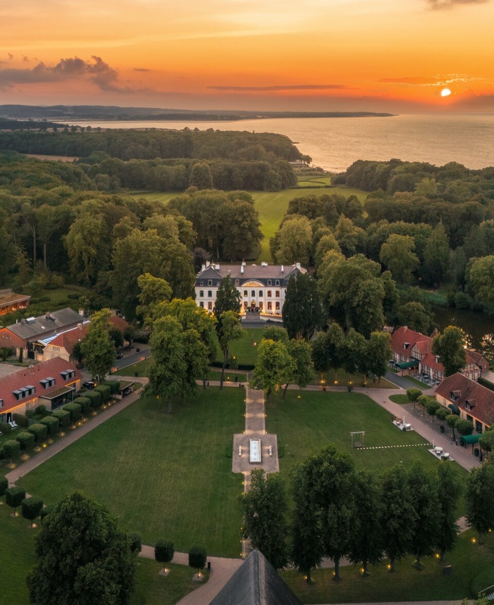 Aerial view of WEISSENHAUS resort and the Baltic Sea at sunset