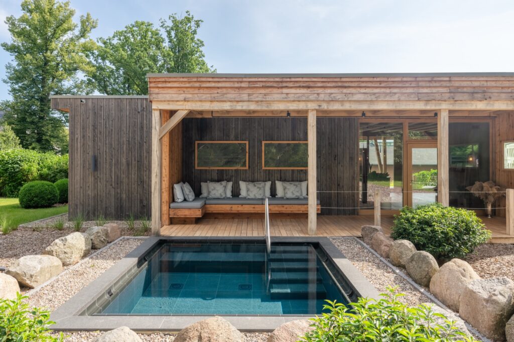 Outdoor onsen pool surrounded by greenery at WEISSENHAUS