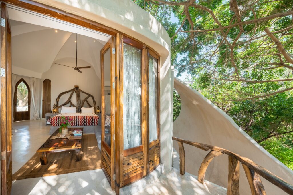Curved villa doorway opening onto a calm bedroom at Xanadu Villas