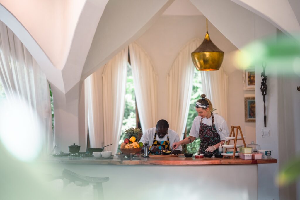 Guests and chefs preparing food during a Zanzibar cooking experience