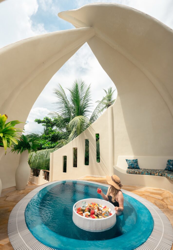 Floating breakfast beneath sculptural white arches at Xanadu Villas